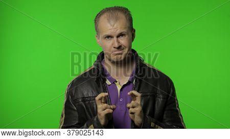 Rocker Man In Brown Leather Jacket Full Of Hope Crossing His Fingers Showing Good Luck Gesture, Wish