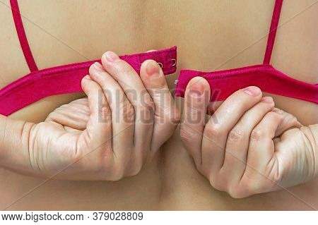 Closeup Of Woman Hands Unfastening Red Bra. Lower Lingerie. Female Hands Unfasten The Red Bra. Back 