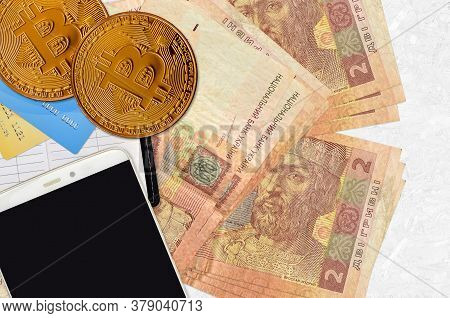2 Ukrainian Hryvnias Bills And Golden Bitcoins With Smartphone And Credit Cards. Cryptocurrency Inve