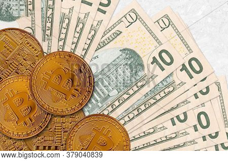 10 Us Dollars Bills And Golden Bitcoins. Cryptocurrency Investment Concept. Crypto Mining Or Trading