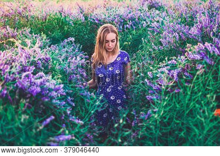 European Blonde Young Slim Girl Walks On Tall Grass
