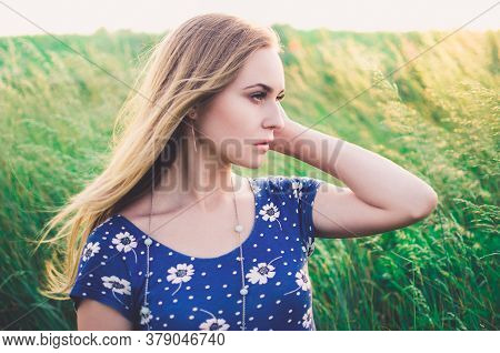 Girl Blonde In A Blue Short Tight Dress Sit In Tall Grass