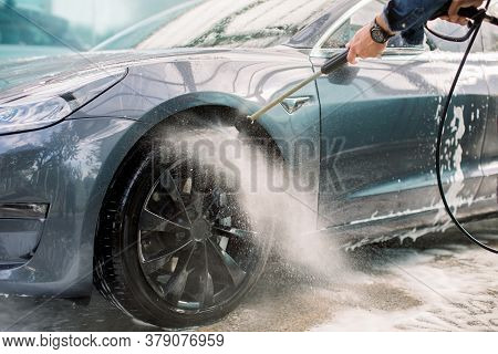 Car Washing Outdoors. Car Washing With Soap And High Pressure Water. Wheel Alloy Cleaning At Car Was