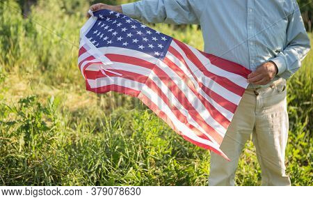 Patriotic Senior Man Celebrates Usa Independence Day On 4th Of July With A National Flag In His Hand