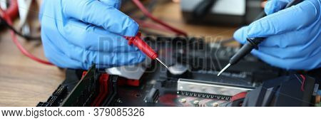 Close-up Of Middle-aged Man Measuring Electrical Voltage. Technician Male Repairing Computer Mainboa