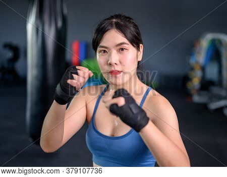 Asian Woman Exercise And Lifestyle At Fitness Gym. Sporty Woman Workout And Boxing With Trainer. Wel