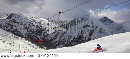 Chair-lift, Snowy Ski Track Prepared By Snowcat, Skiers On Ski Resort. High Winter Mountains And Blu