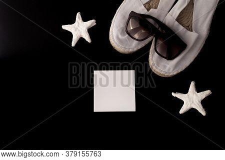 Flat Lay Of Summer And Beach Holiday. Starfish, White Espadrilles, White Letterhead In Black Backgro