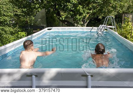 Two Teenagers Swim In The Summer Race In Their Home Pool. Outdoor Sports, Tempering And Water Treatm