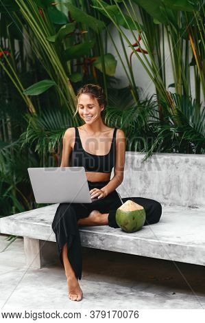 Woman Freelance Work Typing On Laptop Poolside Outdoors With Fresh Coconut . Traveling With A Comput