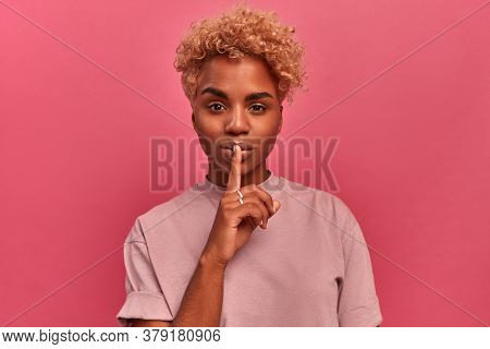 Emotional Surprised Dark Skinned Student Makes Hush Gesture, Asks Be Quiet, Has Scared Expression As
