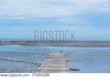 Wooden Walk Way And Sea Shore On Blue Sky Background During Low Tide At The Leam Phak Bia Environmen