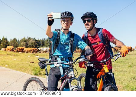 Two Young Cyclists Taking A Selfie With The Phone During Their Mountain Bike Route, Concept Of Sport