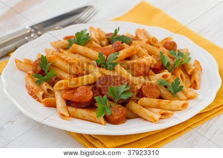 Pasta con salsicce sul piatto bianco