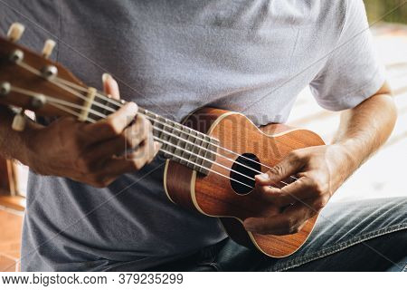 Close Up Young Man Hands Playing Ukulele Guitar