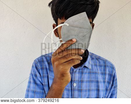 Young Man Covering His Face With Grey Color Kn-95 Face Mask. Blue Shirt Guy. Corona Virus Protection