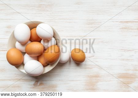 Brown And White Eggs In Plate And Two Near On Wood Background. Free-range Organic Eggs In Bowl. Bowl