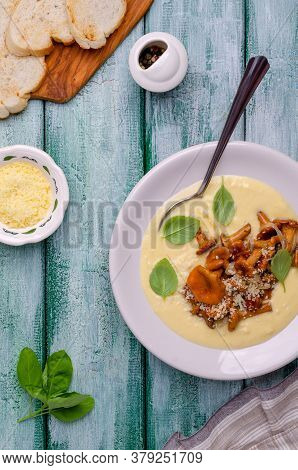 Traditional Polenta With Mushrooms And Cheese In A Dish On A Green Wooden Background. Selective Focu