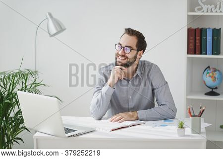 Pensive Young Bearded Business Man In Gray Shirt Glasses Sit At Desk Work On Laptop Pc Computer In L