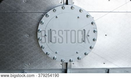 An Industrial Metal Hatch Closed With Bolts. Silver Metallic Color. Vintage Metal Hatch With Bolts.