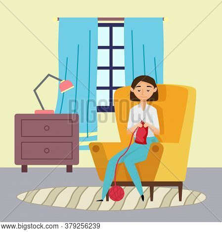 Smiling Young Woman Knitting Red Scarf Sitting In Armchair At Home. Chest Of Drawers With Lamp, Wind