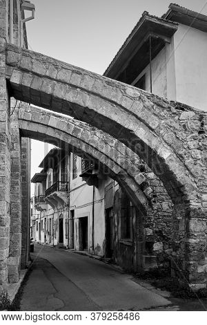 Old street in Larnaca under ancient buttresses of The Great mosque, Cyprus.  Black and white architectural photography