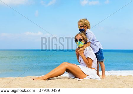 Mother, Child In Stylish Masks Have Fun On Sea Sand Beach. New Rules To Wear Face Covering At Public