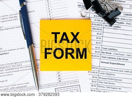 Text Tax Form On Note Paper With Pen And Glasses