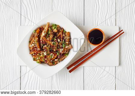 Gaji Namul, Steamed And Seasoned Eggplant In A White Bowl On A Wooden Table With Soy Sauce And Chops