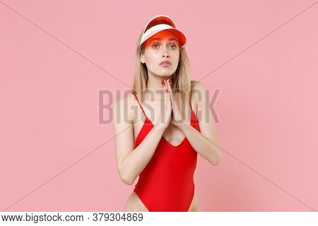 Pleading Young Blonde Woman Girl In Red One-piece Swimsuit Cap Isolated On Pink Background In Studio