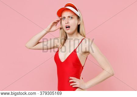 Shocked Perplexed Young Blonde Woman Girl In Red One-piece Swimsuit Cap Posing Isolated On Pink Back
