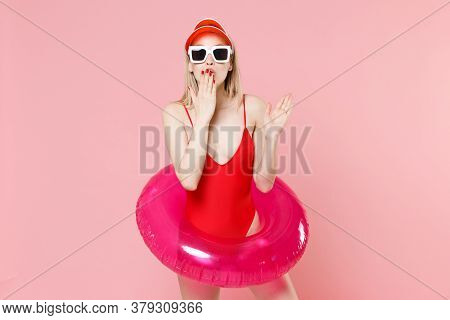 Shocked Young Blonde Woman Girl In Red One-piece Swimsuit Cap Glasses With Swim Inflatable Ring Isol