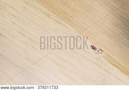 Aerial View. Tractor With Seed Drill Machine Sowing The Seeds For Crops In Spring Season. Beginning 