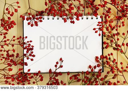 Autumn Mock Up.autumn Flat Lay. Blank Notebook And Branches With Red Berries On A Yellow Wooden Back