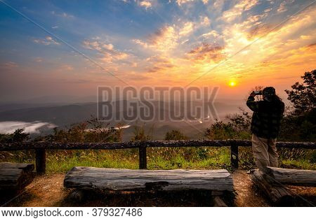 Tourists Standing On The Edge Of The Cliffs Taking Pictures Of The Sunrise At Doi Samer Dao. See The