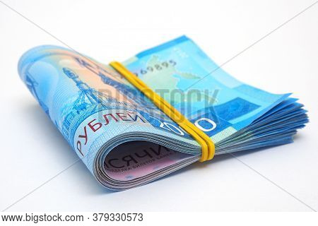 A Rolled Up Bundle Of Russian Banknotes Of 2000 Rubles Lies On A White Paper Background. Banknotes T