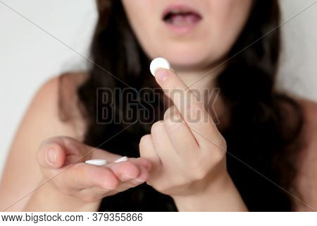 Woman With Pills, White Tablet In Female Hand. Girl With Long Curly Hair Taking Medication, Concept 