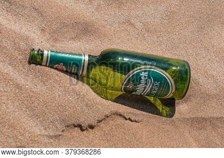 Walvis Bay, Namibia - June 8, 2011: An Empty Beer Bottle On Dune 7 At Walvis Bay On The Atlantic Oce