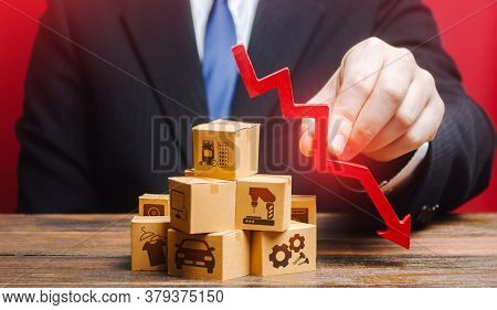 Businessman Holds A Red Down Arrow Over The Boxes. Business Industrial Production Drop Rate. Shortag