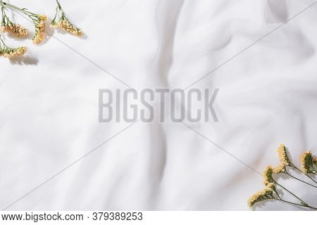 Top view of voile fabric background with flowers in two corners with space for text