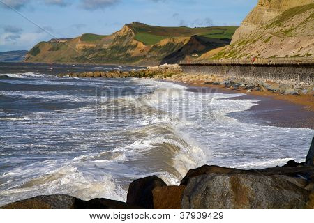 Vlny tříštící se o West Bay pláž Dorset
