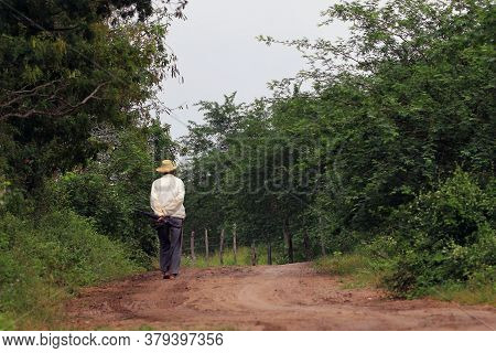 Conceição Do Coité, Bahia, Brazil - 07.29.2020. Elderly Man Walking Alone On Foot, Barefoot, With An