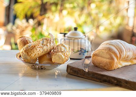 Cafe Table With Breads, Crackers And Accessories With Blurred Background, Natural Light On White Tab