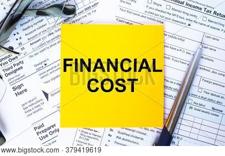 Text Financial Cost On Note Paper With The U.s Irs 1040 Form,pen And Glasses
