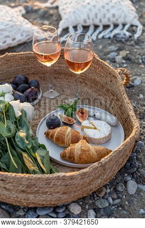 Vertical Image Of The Outdoor Picnic With Wine, Figs, Croissants And Camamber Cheese In A Woven Bask