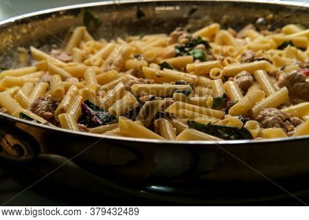 Italian White Wine Alfredo With Penna Pasta Sausage Cannellini And Red Chard Greens Cooking In Large