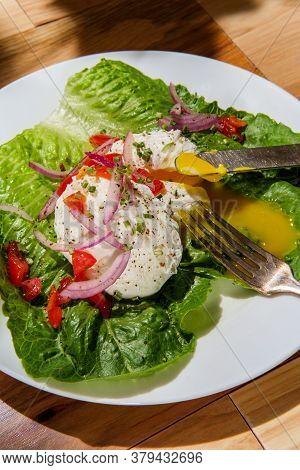 Poached Eggs With Runny Yolk On Bed Of Romaine Lettuce Topped With Red Onions Tomatoes Chives Salt A