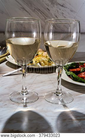 Romantic Italian Dinner With Two Glasses Of Pinot Grigio White Wine And Fettuccine Alfredo Shrimp In