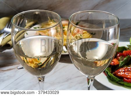 Romantic Italian Dinner With Two Glasses Of Pinot Grigio White Wine And Fettuccine Alfredo Shrimp In