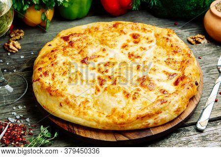 Khachapuri In Megrelian On The Board. Azerbaijani Restaurant Dish With Vegetable Decor On A Wooden B